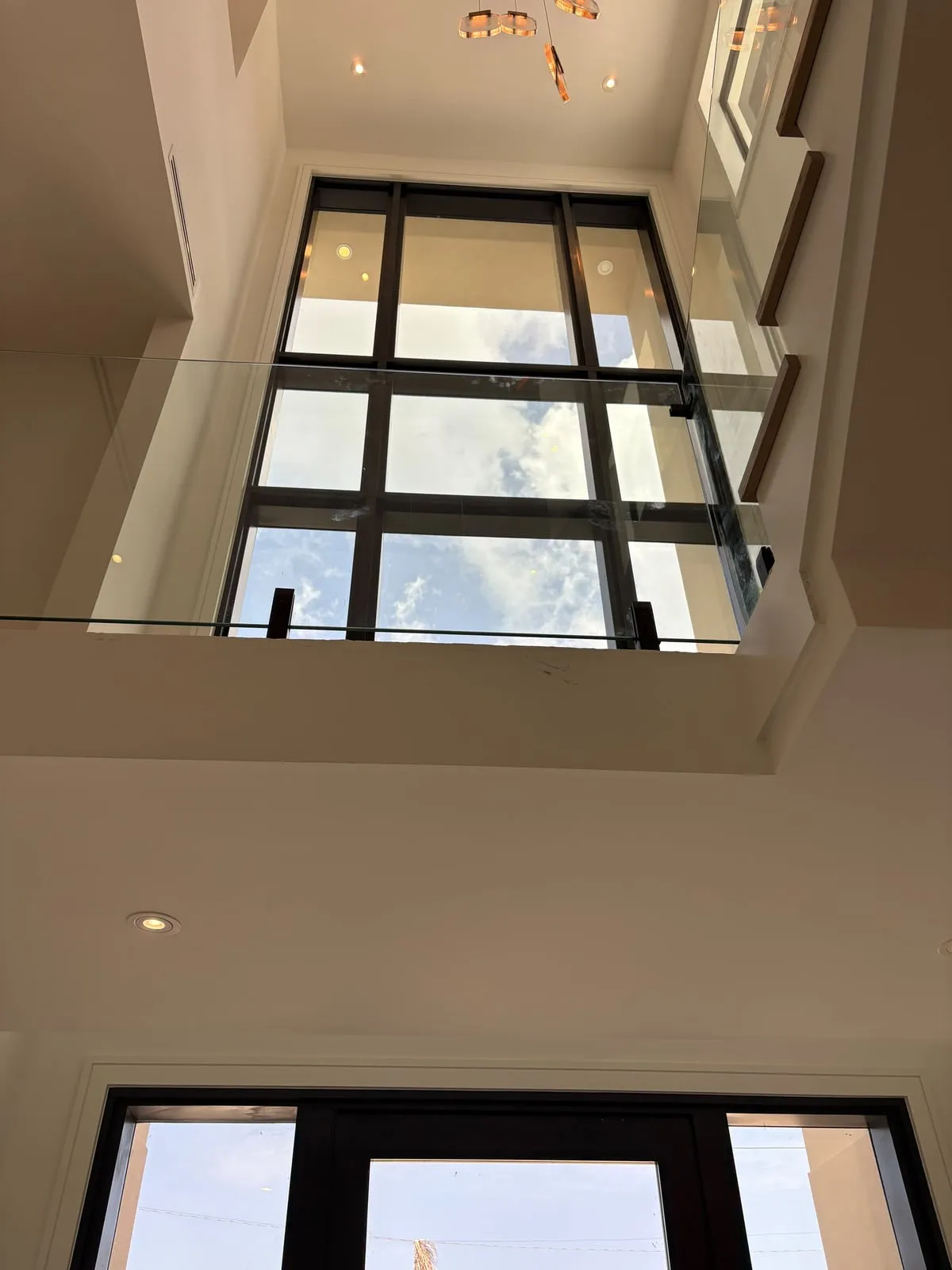 Two-story foyer with tall windows and a glass railing
